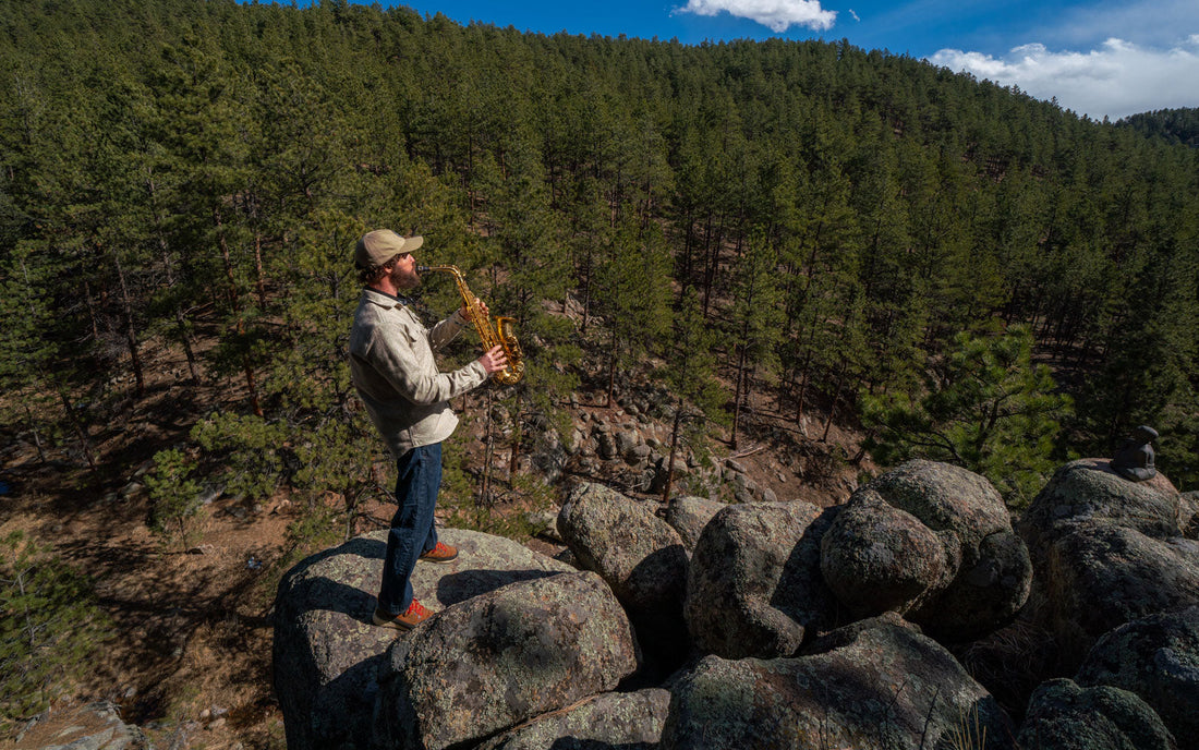 Image of Man in MuskOx Flannel Playing the Saxophone on a Hike 